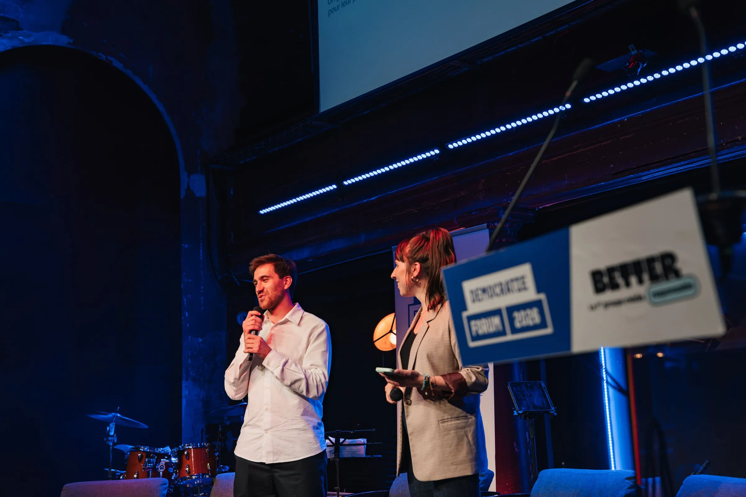 Vincent Touboul Flachaire et Claire Pétreault sur scène, micro à la main, devant le pupitre du forum.